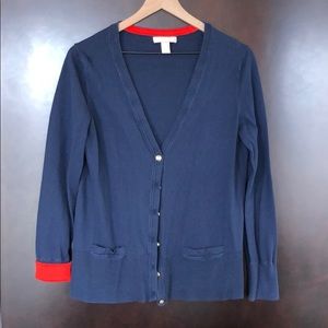 Navy sweater with orange accents and gold buttons